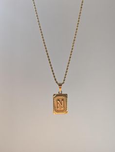 18K Gold Plated Rectangular Medallion Letter Pendant Necklace. High quality gold plating made to be waterproof, hypoallergenic and Tarnish resistant. A substantial piece you can feel in it's weight, with unique personalization, making the iconic initial style pendant more unique with the intricate details. This necklace is made to be unisex and will suit the style of any individual; perfect for everyday wear.  Features: - 316L Stainless Steel plated with 18K gold. - Hypoallergenic, waterproof an Necklace Initial Letter, Jewelry Letter, Initial Letter Necklace, Custom Jewelry Box, Necklace Initial, Letter Pendant Necklace, Gold Long Necklace, Initial Pendant Necklace, Mens Pendant