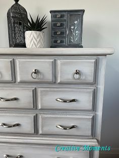 a white dresser with silver handles and drawers