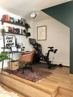 there is a bike sitting on the floor in this home office area with shelves above it