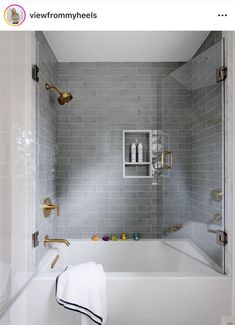 a white bath tub sitting inside of a bathroom next to a shower head and hand held faucet