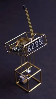 an electronic device with the time displayed on it's display stand that is made out of gold metal