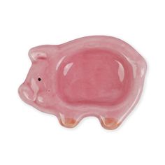 a pink pig shaped dish sitting on top of a white table