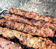 several skewers of meat sitting on top of a grill