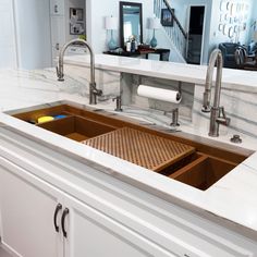 a kitchen sink with a drainer in the middle and a counter top under it