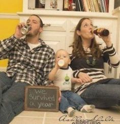 a man and woman are sitting on the floor drinking from their baby's bottles