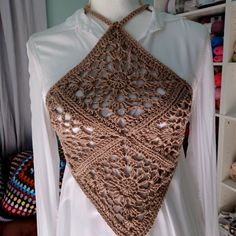 a crocheted shawl is displayed on a mannequin