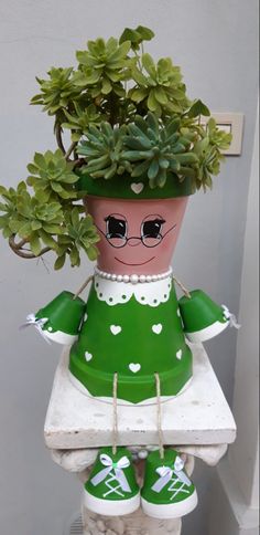 a green potted plant sitting on top of a white statue