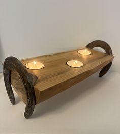 a wooden tray with three candles on it