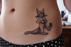 a woman's stomach with a cat tattoo on her belly and the bottom part of her lower body