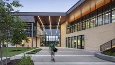 a person walking down a walkway in front of a building