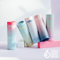 five different types of skin care products are on top of a pink and white block