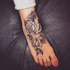 a woman's foot with a rose tattoo on it