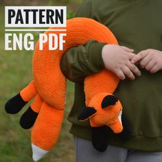 a child holding an orange and black knitted animal with text overlay that reads, pattern eng pdf