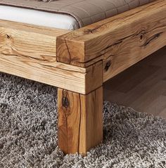 a wooden bed frame sitting on top of a carpeted floor