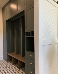 an empty walk in closet next to a white wall and black and white checkered floor