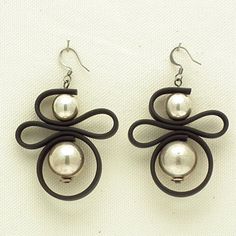 the earrings are made out of black leather and pearl beads with spirals on them