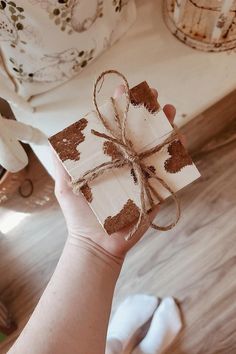 a person holding a piece of paper wrapped in twine and tied with brown string