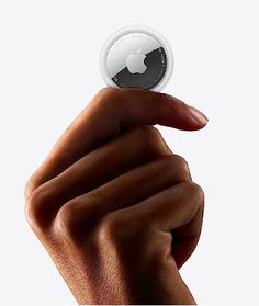 a hand holding an apple button in the air