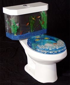 a white toilet with a fish tank on the lid and side panel in front of it