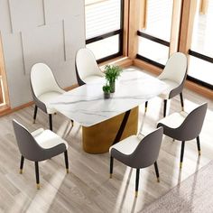 a dining room table with chairs and a plant in the center, surrounded by windows