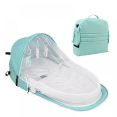 a baby crib that is next to a backpack and bag on the ground with it's cover open