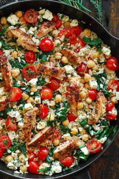 a skillet filled with chicken, tomatoes and chickpeas