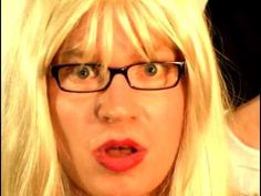 a blonde woman with glasses making a surprised face