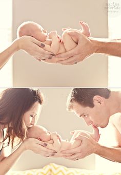 a man and woman holding a baby in their hands