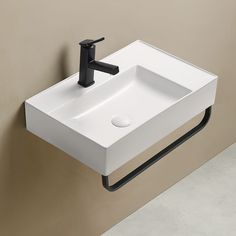 a white sink mounted to the side of a wall next to a black faucet