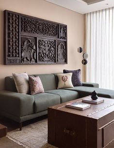 a living room with a couch, coffee table and large wooden paneled artwork on the wall