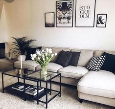 a living room with couches, tables and pictures on the wall above them in black and white