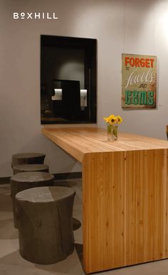 a wooden counter sitting in the middle of a room next to stools and tables