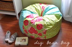 a pair of shoes sitting on the floor next to a flowery bean bag chair