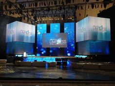 the stage is set up for an event with blue lights and large screens on it