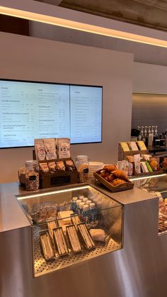 a display case filled with lots of different types of food next to a flat screen tv