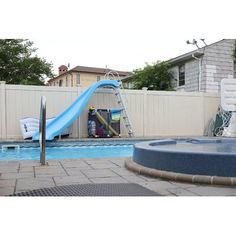 an inflatable slide next to a swimming pool with a blue water slide on it