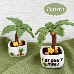 two small crocheted palm trees sitting on top of a green blanket