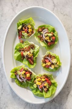 lettuce wraps with meat and vegetables on a white plate, ready to be eaten