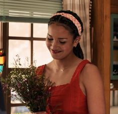 a woman in a red dress holding a bouquet of flowers