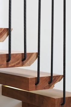 a set of stairs made out of wood and black metal bars on each handrail