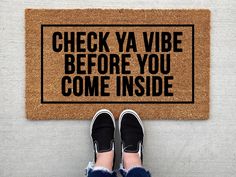 someone standing in front of a door mat that says check ya vibe before you come inside