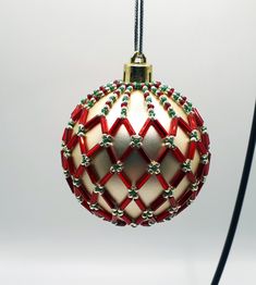 a red and white ornament hanging from a black cord