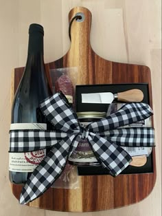 a wooden cutting board with wine, cheese and other items