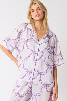 Peach Love California Light purple satin button down pajama top with dark purple bow tie print Purple Sleepwear For Spring Pajama Party, Purple Sleepwear For Pajama Party In Spring, Purple Short Sleeve Sleepwear For Pajama Party, Spring Purple Satin Top, Purple Satin Top For Spring, Purple Satin Sleepwear, Casual Purple Top For Bedtime, Purple Sleep Tops For Spring, Purple Spring Sleep Top