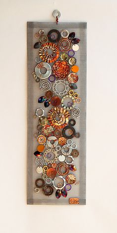 a piece of artwork hanging on the wall with buttons and magnets attached to it