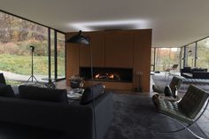 a living room with couches, chairs and a fire place in the middle of it