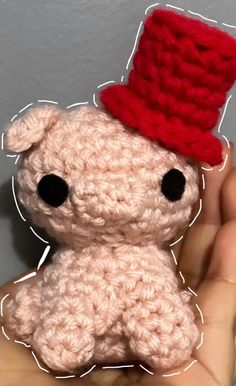 a small crocheted teddy bear with a red hat on it's head