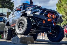 an off - road vehicle parked on top of a rock in front of other vehicles