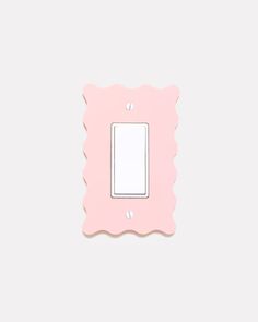 a pink light switch cover on a white wall with a scalloped border around it