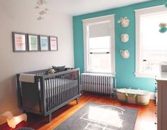 a baby's room with blue walls and wood floors, including a crib